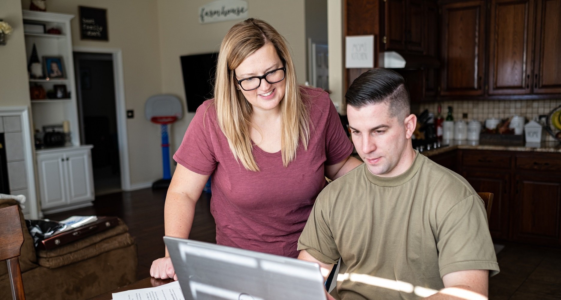 Military couple looking at laptop smiling